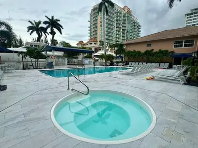 a large swimming pool with a tub in the middle of it at 3Bd 2Bath 1 Block from the beach! Newly renovated in Fort Lauderdale