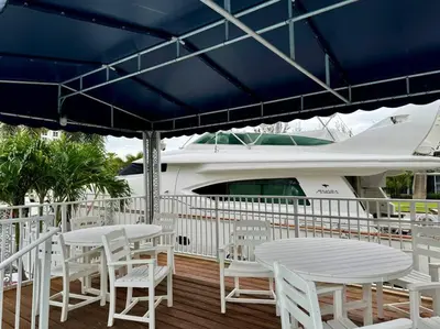 a deck with white tables and chairs and a boat at 3Bd 2Bath 1 Block from the beach! Newly renovated in Fort Lauderdale
