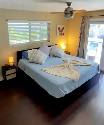 a bedroom with a large bed with a dress on it at Heated Pool Private Duplex House, BBQ, Parking, WiFi in Cutler Bay