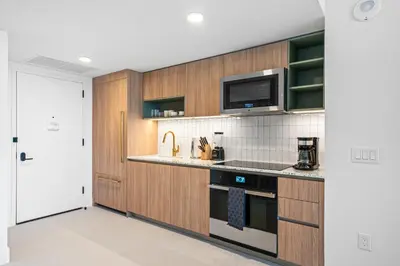 a kitchen with wooden cabinets and a microwave at New Luxury 26th Floor Apartment in the heart of Miami in Miami