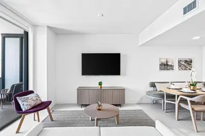 a living room with a tv on a wall at New Luxury 26th Floor Apartment in the heart of Miami in Miami