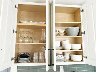 a cupboard filled with plates and bowls and dishes at AQUAMARIA HOME - perfect stay for groups in Fort Lauderdale