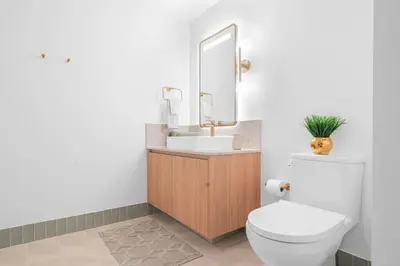 a bathroom with a toilet and a sink and a mirror at Lux 2BR Natiivo Condo With Pool, Spa and Gym Access in Miami