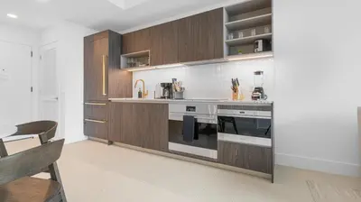 a kitchen with wooden cabinets and a large stove at 49th Floor Sleek Condo Cozy Pool, Gym and Spa Stay in Miami