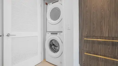 a laundry room with a washing machine next to a door at 49th Floor Sleek Condo Cozy Pool, Gym and Spa Stay in Miami