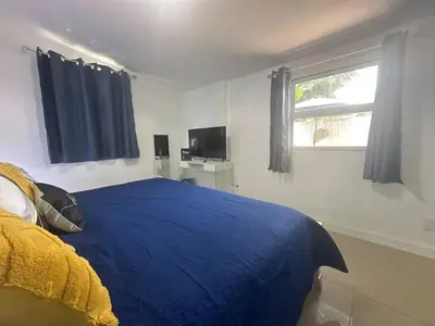 a bedroom with a blue bed and a window at Relaxing Studio Getaway w BBQ, Patio and Parking in Pembroke Pines