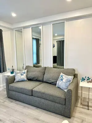 a living room with a gray couch in a room at Beach Getaway in Hollywood