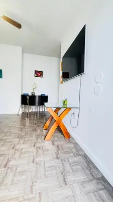 a dining room with a table and a television on a wall at Apt 202 Near Cruise Port, 5 Min to Downtown, 4 Min to Trains, 14Min to Airp in Miami