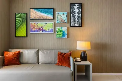 a living room with a couch and pictures on the wall at Seaside Splendor! Modern Condo with Ocean View in Hollywood
