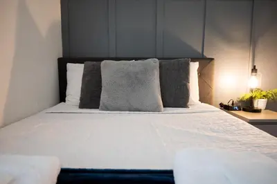 a bedroom with a large bed with pillows at Cozy Central Stay Airport, KingBed, Fenced Parking - Little Havana Near Airport, Wynwood, Calle 8 Brickell, Coral Gables and more in Miami