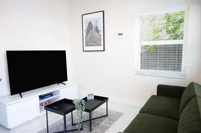 a living room with a couch and a flat screen tv at Cozy Central Stay Airport, KingBed, Fenced Parking - Little Havana Near Airport, Wynwood, Calle 8 Brickell, Coral Gables and more in Miami