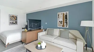a living room with a couch and a bed and a tv at The Logan I in Miami