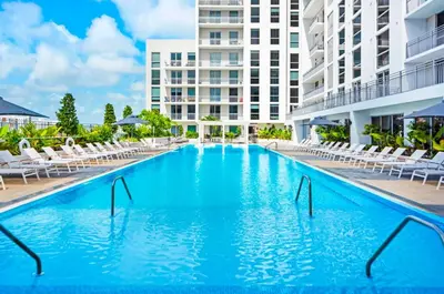 a large swimming pool with chairs and a building at The Logan I in Miami