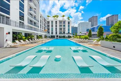 a swimming pool with lounge chairs and a building at The Logan I in Miami
