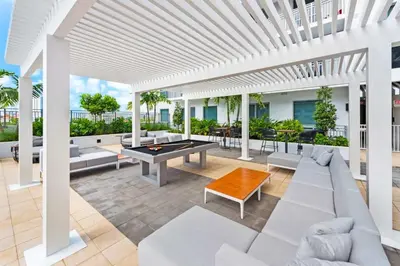 a patio with a ping pong table and couches at The Logan I in Miami