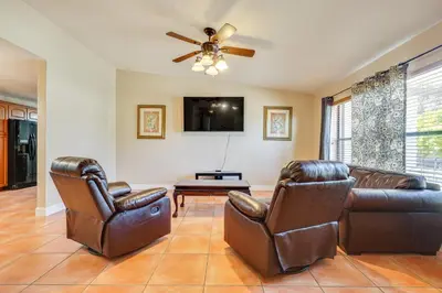 a living room with two leather chairs and a tv at Pet-Friendly Home with Yard about 3 Mi to Zoo Miami! in Cutler Ridge