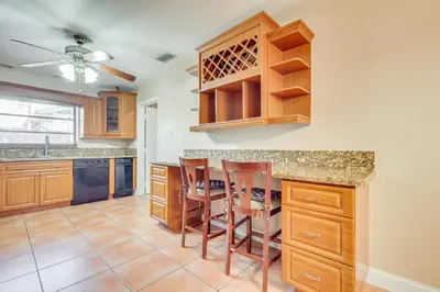a kitchen with wooden cabinets and a table and chairs at Pet-Friendly Home with Yard about 3 Mi to Zoo Miami! in Cutler Ridge