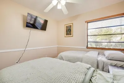 a bedroom with two beds and a flat screen tv at Pet-Friendly Home with Yard about 3 Mi to Zoo Miami! in Cutler Ridge