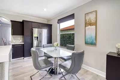 a kitchen and dining room with a table and chairs at Luxury Tropical Living , 4BR w Backyard Pool Oasis in Hialeah