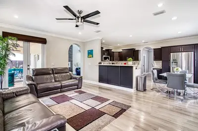 a living room with a couch and a ceiling fan at Luxury Tropical Living , 4BR w Backyard Pool Oasis in Hialeah