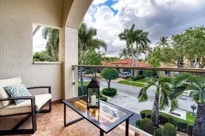 a living room with a glass table and a balcony at Luxury Tropical Living , 4BR w Backyard Pool Oasis in Hialeah