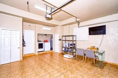 a room with a table and chairs and a kitchen at Luxury Tropical Living , 4BR w Backyard Pool Oasis in Hialeah