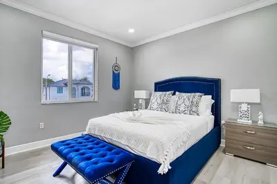 a blue bed with a blue bench in a bedroom at Luxury Tropical Living , 4BR w Backyard Pool Oasis in Hialeah
