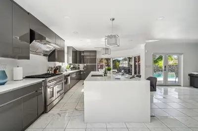 a kitchen with a white island in the middle at Tropical Pool Paradise x 6-BD 4-BA Luxury Living in Hialeah