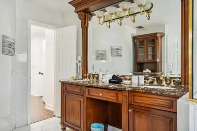 a bathroom with a sink and a large mirror at Tropical Pool Paradise x 6-BD 4-BA Luxury Living in Hialeah