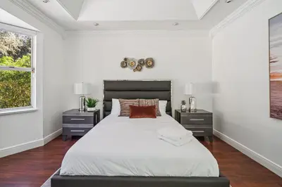 a white bedroom with a large bed and two night stands at Tropical Pool Paradise x 6-BD 4-BA Luxury Living in Hialeah