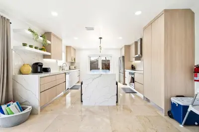 a kitchen with marble counter tops and wooden cabinets at 6-BD 3-BA Dreamy Vacation Retreat in Coral Terrace in Miami