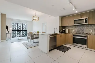 a kitchen with stainless steel appliances and a dining room at Wonderful 2 bedroom Apartment in Downtown Doral in Miami