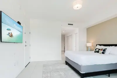 a bedroom with a large bed and a tv on the wall at Wonderful 2 bedroom Apartment in Downtown Doral in Miami