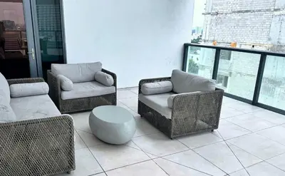a living room with wicker chairs and a table at Private Terrace in Luxury 3BR Condo in Brickell in Miami