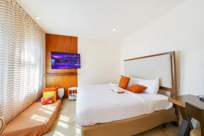 a bedroom with a large white bed and a desk at Casa Victoria Orchid Hotel in Miami Beach