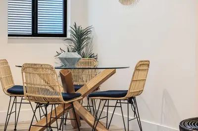a dining room table and chairs with a plant at Roami at The Palace in Miami