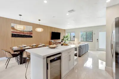 a kitchen and dining room with a kitchen island and a table at Zen Den - Heated Pool, Work Friendly, Near Beach in Fort Lauderdale