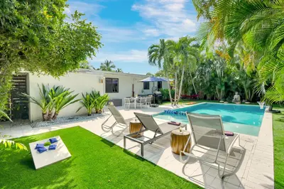 a patio with chairs and a swimming pool at Zen Den - Heated Pool, Work Friendly, Near Beach in Fort Lauderdale