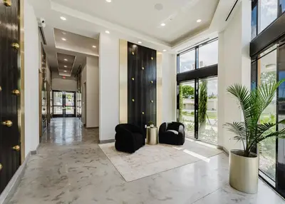 a hallway with black chairs and a potted plant at Prime 2BR by FLL Airport & Dania Beach Attractions in Fort Lauderdale