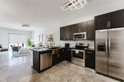 a kitchen with black cabinets and stainless steel appliances at Prime 2BR by FLL Airport & Dania Beach Attractions in Fort Lauderdale
