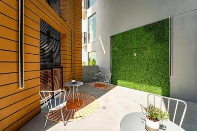 a patio with chairs and tables and a green wall at Prime 2BR Near FLL Airport, Dania Beach & Pointe in Fort Lauderdale