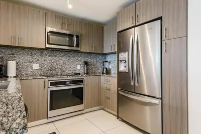 a kitchen with stainless steel appliances and wooden cabinets at Wonderful 1 bedroom Apartment in Downtown Doral in Miami