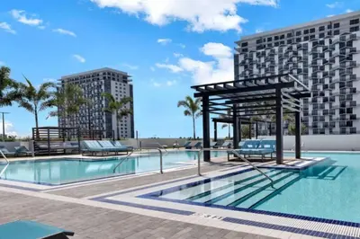 a swimming pool at a resort with two tall buildings at Wonderful 1 bedroom Apartment in Downtown Doral in Miami