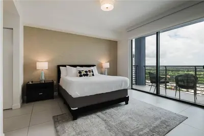 a bedroom with a large bed and a balcony at Wonderful Studio Apartment in Downtown Doral in Miami