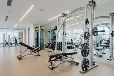 a gym with several treadmills and machines at Wonderful Studio Apartment in Downtown Doral in Miami