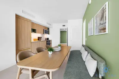 a dining room with a wooden table and a couch at Luxury Apartment 3 Bedrooms Pool Gym Views & More in Miami