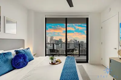 a bedroom with a bed with a view of the city at Spectacular Apartment with Pool & Gym in Miami