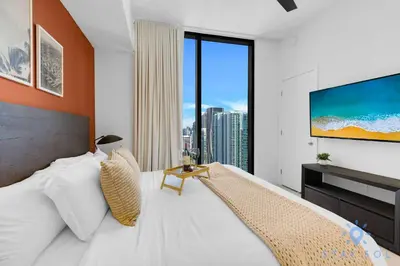 a bedroom with a large bed with a large window at Chic Downtown - City Views Gym & Pool in Miami
