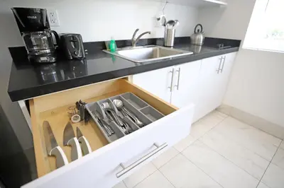 a kitchen with a sink and a drawer full of knives at 3 Minute Walk to Miami Beach Family and Pet Friendly Apartment in Miami Beach