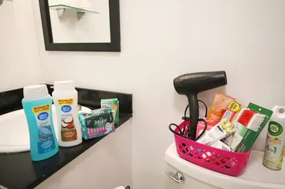 a bathroom with a basket on the back of a toilet at 3 Minute Walk to Miami Beach Family and Pet Friendly Apartment in Miami Beach